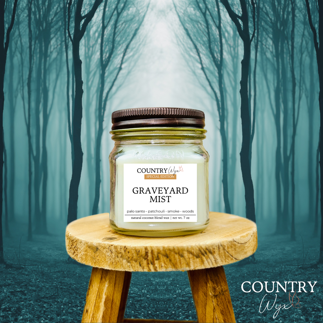 Graveyard Mist 8oz candle by Country Wyx on a wooden stool with a spooky forest background