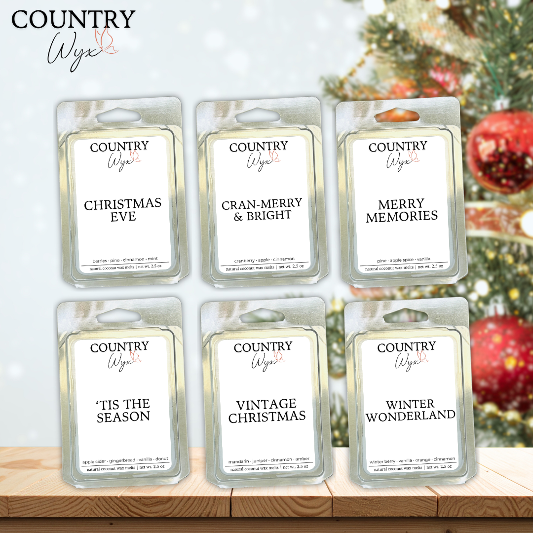 Bundle of six Country Wyx wax melts with winter-themed names against a blurred Christmas tree with ornaments background.