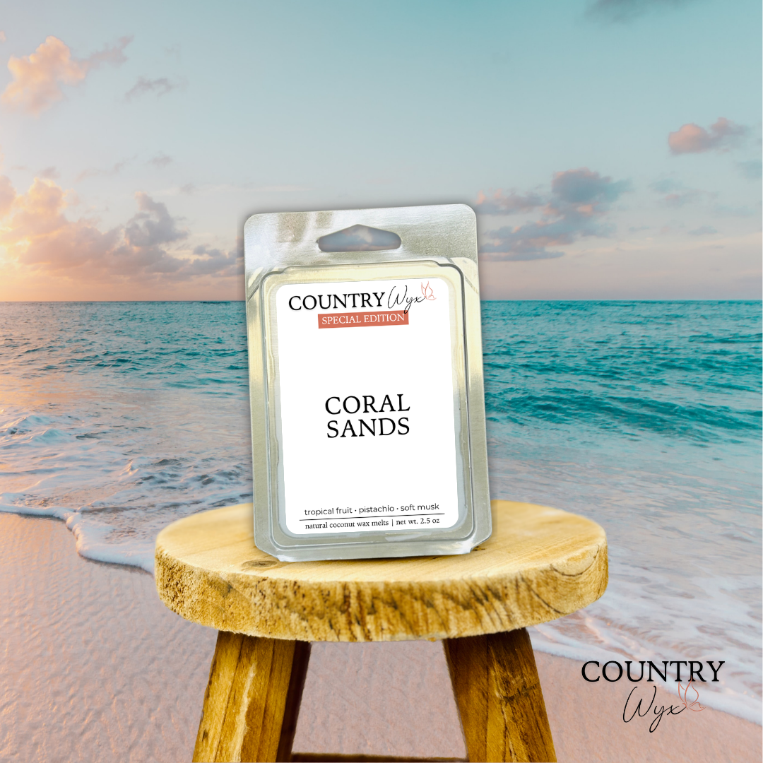 Coral Sands wax melt by Country Wyx on a wooden stool with a beach background