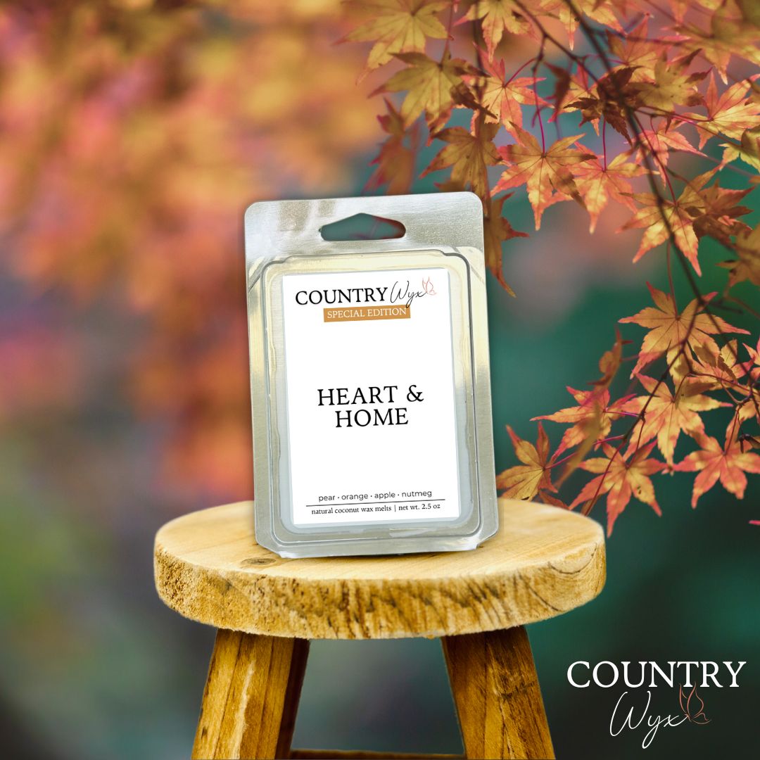 Heart &amp; Home wax melt on a wooden stool with autumn leaves in the background