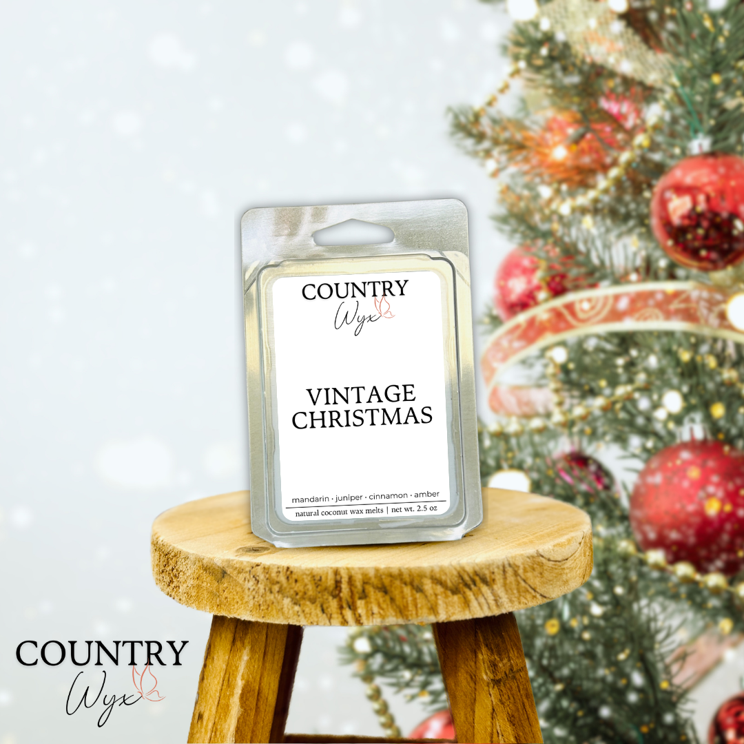 Vintage Christmas wax melt by Country Wyx on a wooden stool with a blurred Christmas tree and ornaments in the background.