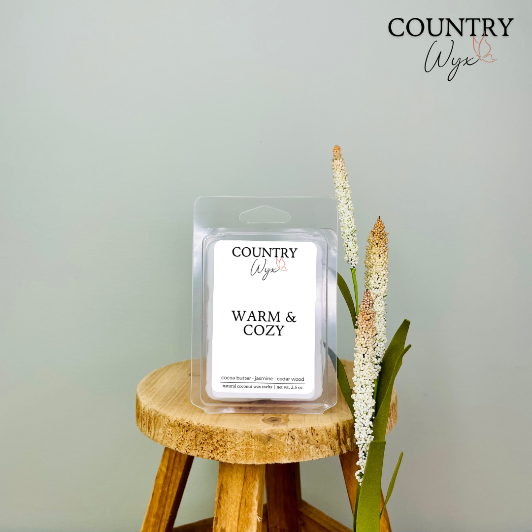 Warm &amp; Cozy wax melt by Country Wyx displayed on a wooden stool with a soft farmhouse-inspired background